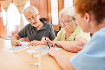Couple of seniors and geriatric nurse solving the puzzle
