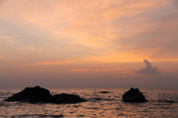 Seascape with dark silhouettes of rocks. Dawn.