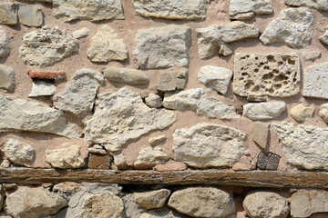 Texture of old stone wall with wooden plank as background, closeup