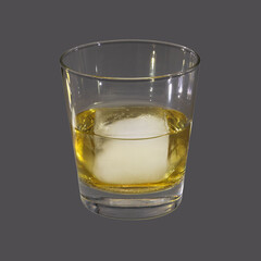 Whiskey on the rocks in a round drinking glass as studio shot with a grey background