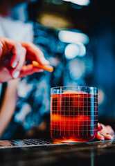 woman hand bartender making negroni cocktail in bar