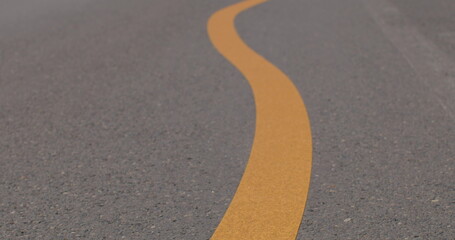 Yellow dividing strip on an asphalt roads. The dashed line changes to a solid curve. Close up....