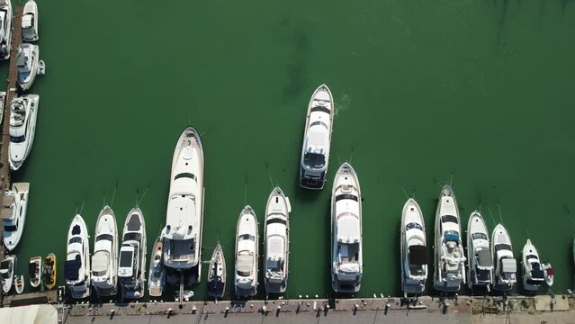 Aerial panoramic view of Balaklava landscape with boats and sea in marina bay. Crimea Sevastopol tourist attraction. Drone top view shot of port for luxury yachts, boats and sailboats.