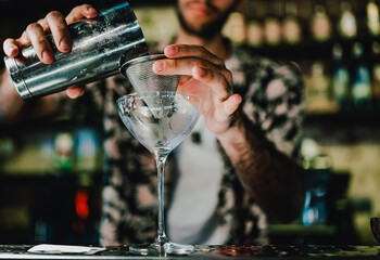 man bartender making cocktail in bar.