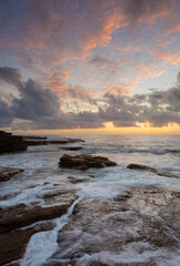 Sunrise over rocky ocean seascape