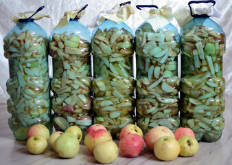 Jabłka pokrojone w plastikowych butelkach. Ocet jabłkowy - obrazy, fototapety, plakaty