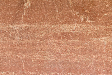 Texture of a stone wall with cracks and scratches which can be used as a backgr. Texture of red stone.