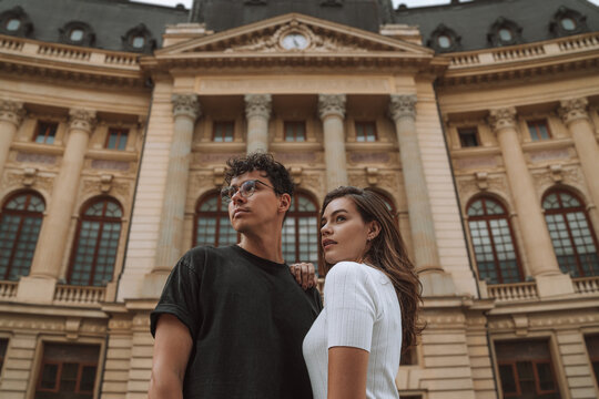 Enamored couple embracing and looking away during sightseeing trip