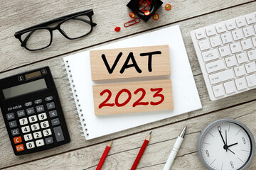black glasses, black calculator, red pencils, keyboard. text. vat 2023