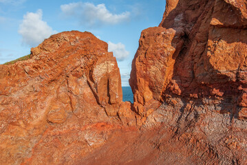 Red laterite rock at Giants Causeway on the Antrim Coast with a view of the Atlantic Ocean at the...