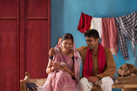 Portrait of Bihar couple using mobile phone at home