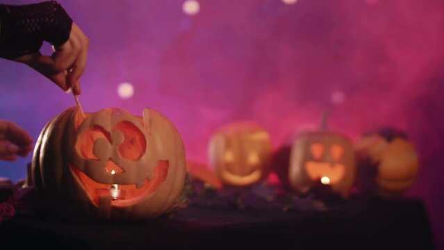 Halloween pumpkins with scary faces.
A hand sets fire to a pumpkin on Halloween. 
High quality  4k footage