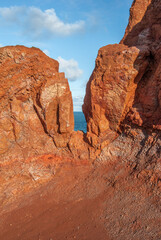 Red laterite rock at Giants Causeway on the Antrim Coast with a view of the Atlantic Ocean at the back in Northern Ireland, UK