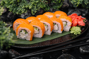 Salmon sushi with rice on black plate