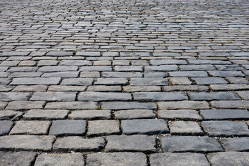 StonStone pavement made of natural stone. The road is paved with gray cobblestonese pavement made of natural stone.