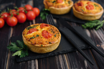 Cheddar cheese and spring onion omelette tarts served on wooden board