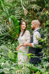 beautiful couple girl and guy in the park among tropical trees