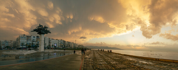Izmir, Turkey - October 15, 2021: Panoramic view of the Gundogdu Square with Tree of Republic Statue, with mammatus cloudy sky
