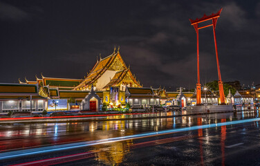 Landmark Wat Suthat Temple in Bangkok at night in a rainstorm