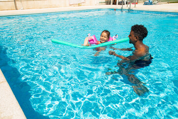 Father and daughter having fun in pool