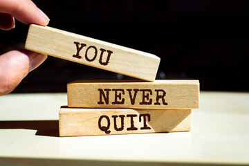 Wooden blocks with words 'You Never Quit'.