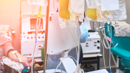 A young man as a blood donor at a donation with his hand clenched into a fist.
