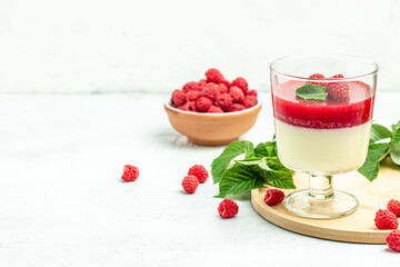 Berry dessert with cream sauce in small jars. Italian dessert. Raspberry Panna cotta with raspberry jelly on a light background. place for text, top view