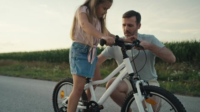 Caucasian Father teaching his little daughter how to ride a bike. Shot with RED helium camera in 8K.   