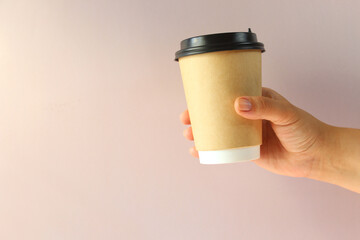 Mockup of woman hand holding a Coffee paper cup on background. Front view. copy space