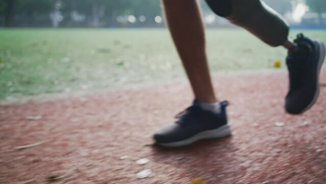 Disabled athlete exercising outdoors running with prosthetic leg