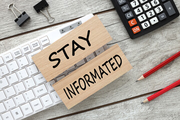 Stay Informed wooden blocks with black text on white keyboard