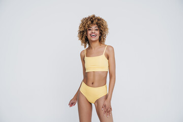 Young black woman wearing underclothes smiling and posing at camera
