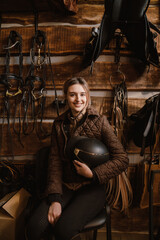 Young jockey woman using mobile phone while sitting in stable