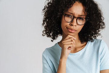 Black puzzled woman wearing eyeglasses posing and looking at camera