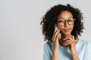 Black curly woman wearing eyeglasses talking and mobile phone