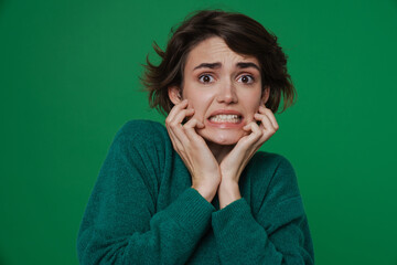 Young scared woman grimacing while looking at camera