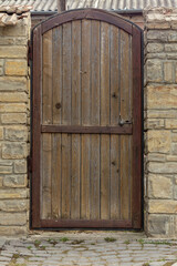 Wooden antique door in a stone wall. Place for an inscription. Copy Space.