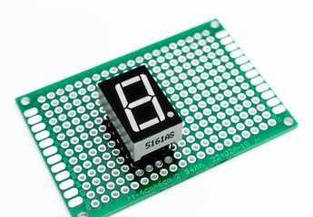 Seven segment indicator attached to a green printed circuit board on a white background. Background picture. Arduino project concept. 