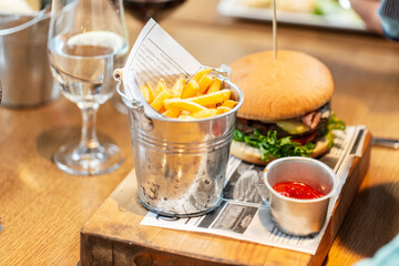 fast food, unhealthy eating and people concept - close up of french fries, ketchup and burger at restaurant