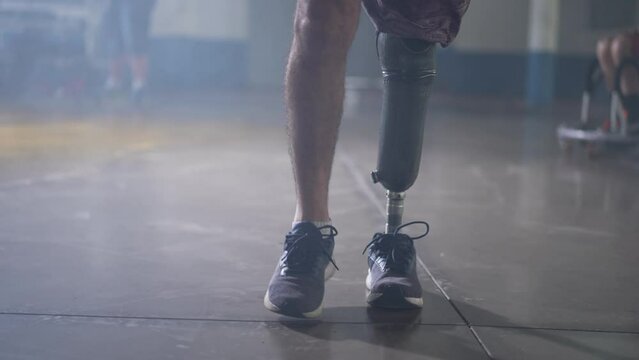 Disabled person walking with his prosthetic leg indoors. Amputee man walks with prosthetis legDisabled person walking with his prosthetic leg indoors. Amputee man walks with prosthetic leg