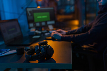 cybercrime, hacking and technology concept - close up of male hacker in dark room writing code or...