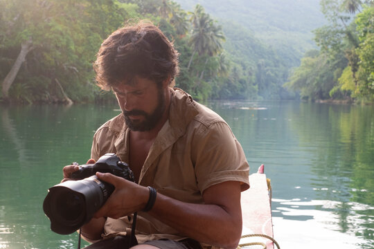 Photographer observes the images of the camera in a jungle lake