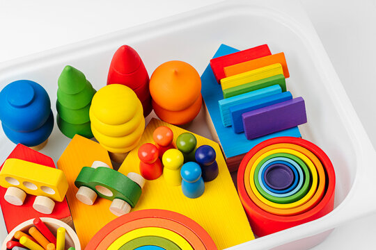 Colorful wooden toys in the colors of the rainbow in plastic box.  Concept of organizing and storing children's toys. Games for learning and development of the child.