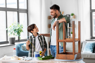 Obraz premium family, diy and home improvement concept - happy smiling father and son with ruler restoring old table at home