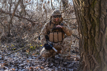 Male modern soldier in the autumn forest 