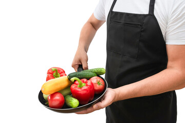 Frying pan with fresh vegetables in the hands of a cook isolated on a white background. Cooking concept