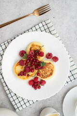 Hot cheesecakes with berries and green tea on concrete background ror breakfast. Top view.