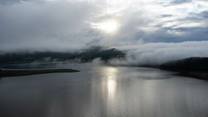 Aerial view from drone, beautiful view of morning mist covering forests and mountains with calm rivers. (Lam Taphen Reservoir), Kanchanaburi Province, Thailand