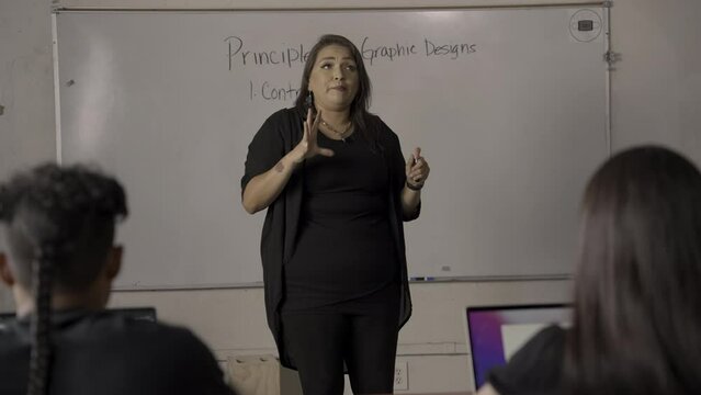 Native American teacher explaining graphic design in class. 