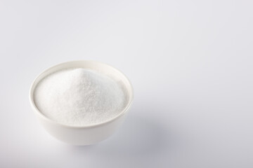 Sugar substitute in a bowl.  Close-up horizontal photo of a sugar substitute on a white background in a white bowl. Stevia.